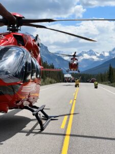 Stars helicopters taking off from a road with mountains in the background