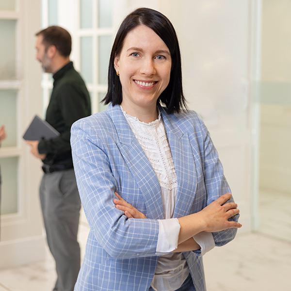 Confident woman with arms crossed standing in corporate board room