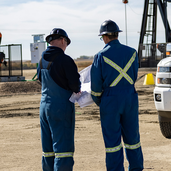 Two Surge Energy field workers on site, conferring