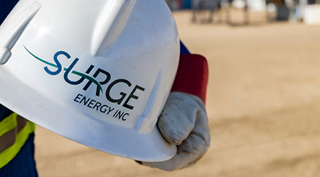 Hand holding Surge Energy hard hat