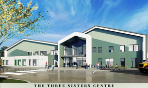 Modern educational building, "The Three Sisters Centre," featuring a large glass entrance with people and children outside, under a bright blue sky.